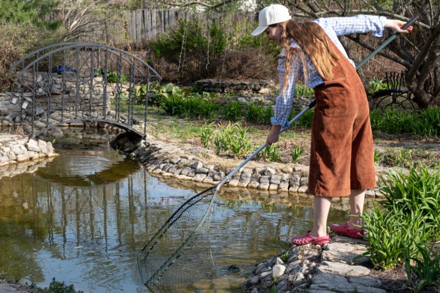 jardinière enlevant les feuilles d'un bassin